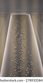 Elegant vertical interior wall panel decorated with flower petals design on premium stucco venetian plaster finish illuminated by warm backlights.  