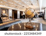 An elegant vintage classic world map model placed on a retro circle dark wood table in the hotel lobby.