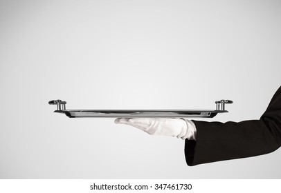 An Elegant Waiter Business Hand In White Glove Holding An Empty Plate With Grey Blank Gradient Background.