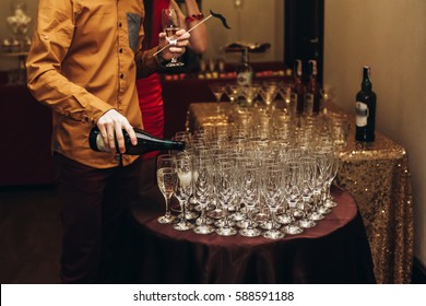 Elegant Waiter Pouring Sparkly Champagne Into Group Of Glasses At Luxury Business Corporate Retreat Party, Restaurant Catering Concept