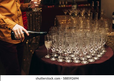 Elegant Waiter Pouring Sparkly Champagne Into Group Of Glasses At Luxury Business Corporate Retreat Party, Restaurant Catering Concept