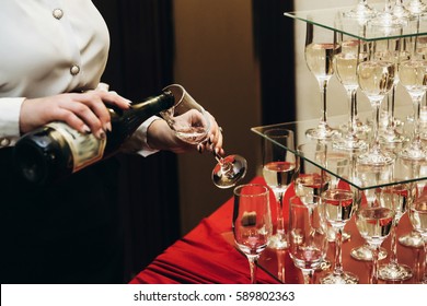 Elegant Waiter Pouring Sparkly Champagne Into Group Of Glasses At Luxury Business Corporate Retreat Party, Restaurant Catering Concept