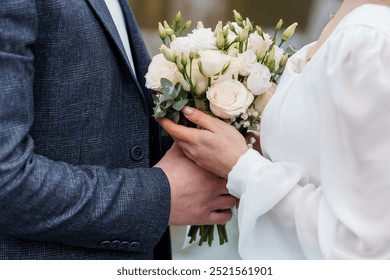 Elegant Wedding Couple Holding a Beautiful Bouquet of White and Green Flowers.