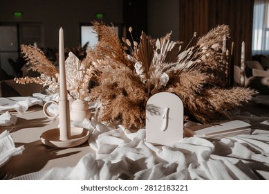 Elegant wedding reception table setting featuring delicate neutral decorations, fine dinnerware, and floral elements for a sophisticated event.