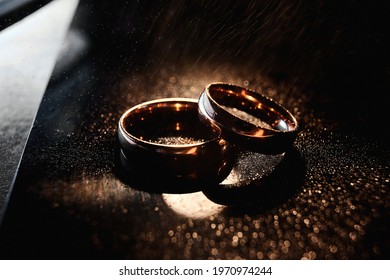 Elegant wedding rings are made of gold. Close-up, macro. Dark background - Shutterstock ID 1970974244