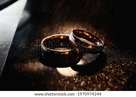 Elegant wedding rings are made of gold. Close-up, macro. Dark background