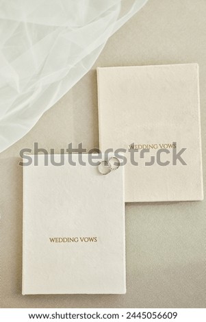 Elegant wedding rings rest on ‘WEDDING VOWS’ booklets