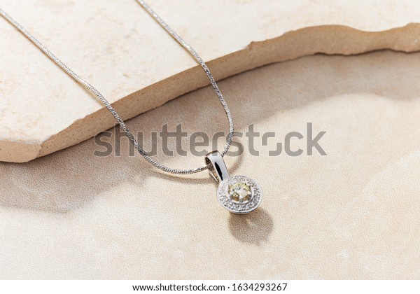 Elegant white gold necklace with diamonds.\
Small silver charm necklace with\
gemstones