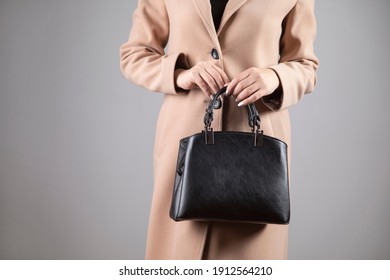 Elegant Woman In Coat Holding Black Bag