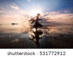 Elegant woman dancing on water. Sunset and silhouette.