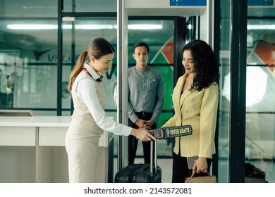 Elegant Woman Passing Through Metal Detector Scanner In Airport Terminal.