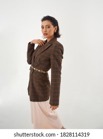 Elegant Woman In Peach Color Silk Slip Dress And Brown Squared Wool Blazer Posing Against Grey Background In Studio. Fashion Look. Caucasian Brunette Female Model With Wet Hair