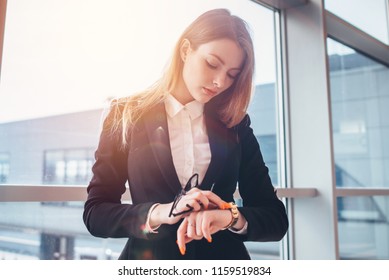 Elegant woman setting her watch standing in airport