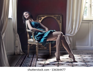 Elegant Woman Sitting On An Antique Chair In The Living Room