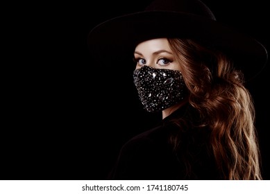 Elegant woman wearing luxury fashion outfit during quarantine of coronavirus outbreak. Black suit including stylish luxury face safety mask with rhinestones. Close up portrait. Copy, empty space