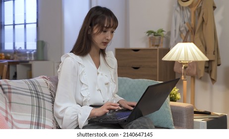 Elegant Woman Working On Laptop In Living Room At Home. Going Back And Forth To Check The Details. Technology, Genuine Lifestyle