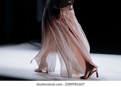 Elegant women's clothing details of fashion beige satin skirt and high heels, Fashion model walking the runway Fashion show