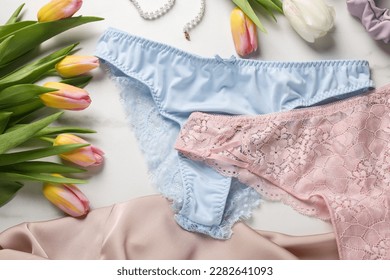 Elegant women's underwear and beautiful tulips on white background, flat lay