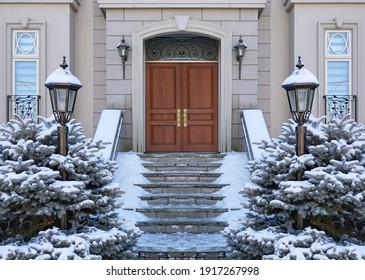 Elegant Wood Grain Front Door Of House In Winter With Snow Covered Pine Bushes