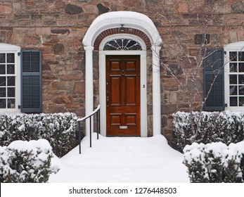 Elegant Wooden Front Door Of House In Winter, Steps Covered In Snow