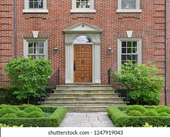 elegant wooden front door of large brick house