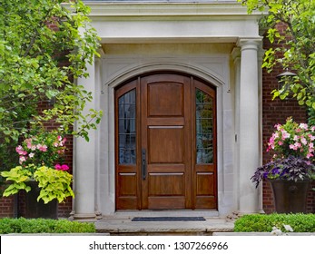 Elegant Wooden Front Door And Portico Entrance Surrounded By Flowers Of Upper Class House