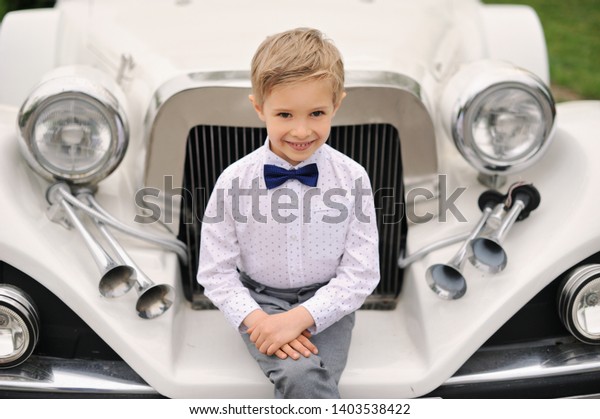 Elegant young boy with\
an expensive car.