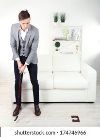 Elegant Young Businessman Playing Mini Golf At Home