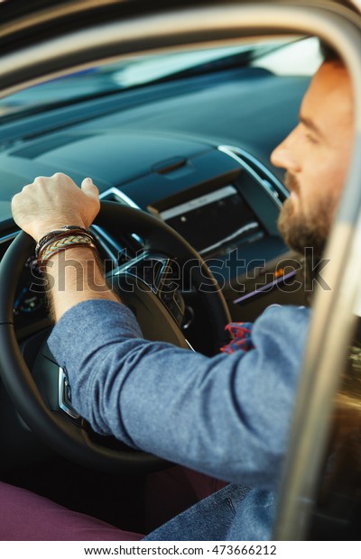Elegant young driver in a\
car