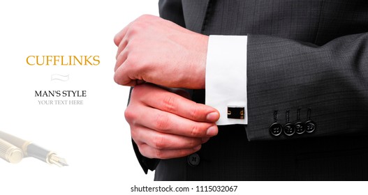 Elegant young fashion man looking at his cufflinks while fixing them.  Creative layout man in black jacket holds cufflinks on isolated background.  Flat lay. Your text here.