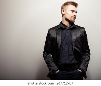 Elegant Young Handsome Man In Black Costume. Studio Fashion Portrait.