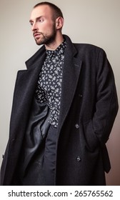 Elegant Young Handsome Man In Long Wool Coat. Studio Fashion Portrait.