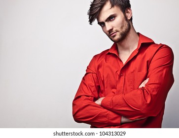 Elegant Young Handsome Man Pose On Red Shirt. Studio Fashion Portrait.