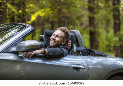 Elegant young happy man in convertible car outdoor.  - Powered by Shutterstock