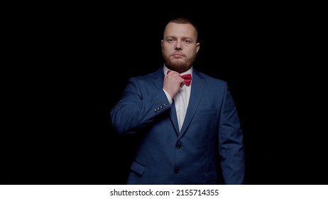 An Elegant Young Man In A Blue Tuxedo, Protruding From The Darkness, Pulls A Tie And Crosses His Arms.