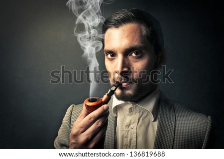 elegant young man smokes a pipe