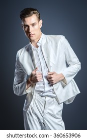 Elegant young man in white suit. Studio fashion shot.