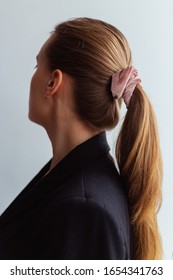 Elegant Young Natural Blonde Woman In Black Business Blazer With Long Ponytail And Velvet Scrunchie In Her Hair, Side View