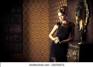 Elegant Young Woman In Black Evening Dress Posing In Vintage Interior. Fashion Shot.