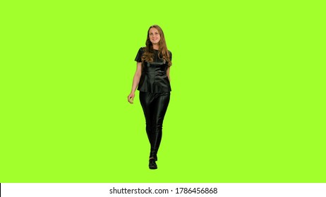 Elegant Young Woman In Black Leather Suit Walks And Smiling On Green Screen Background, Chroma Key