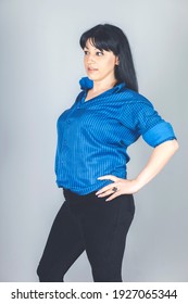 Elegant Young Woman Dressed In Black Skinny Jeans, Blue Shirt Posing