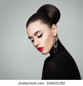 Elegant Young Woman With Hair Bun Hairstyle And Eyeliner Make Up. Female Model Wearing Black Roll Neck Jumper. 