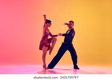 Elegant young woman and handsome man, ballroom dancers in motion, dancing against gradient pink yellow background in neon light. Concept of dance class, hobby, art, dance school, talent - Powered by Shutterstock