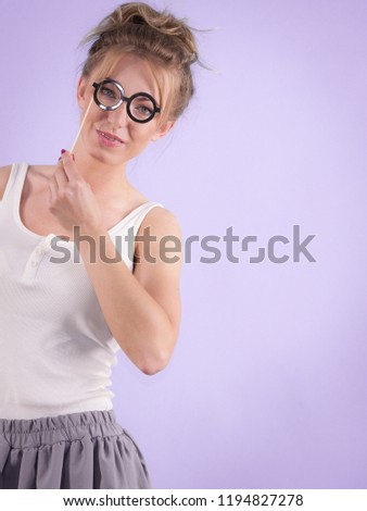 Elegant young woman pretending wearing funny nerd eyeglasses. Education and studying females look concept.