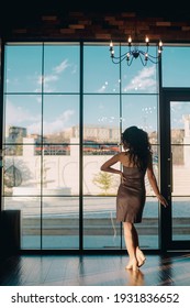 Elegant Young Woman Standing In Front Of Sliding Glass Door In Luxury Restaurant