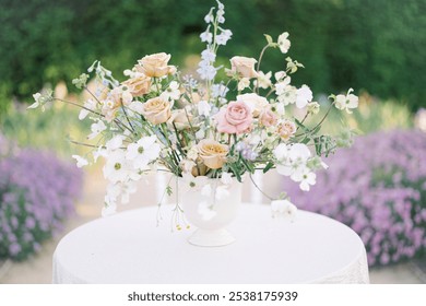 An elegantly arranged garden table with floral centerpieces and candles, creating an enchanting setting for outdoor dining. - Powered by Shutterstock