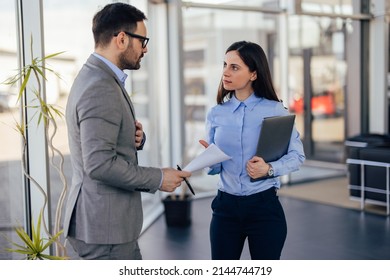 Elegantly Dressed Business People, Talking In The Company Hallway.