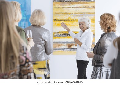 Elegantly Dressed Older Lady Talking About Painting During Its Premiere