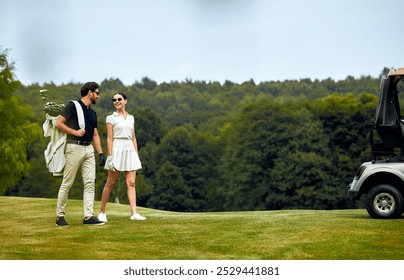 An elegantly fashionable couple strolls across the beautiful golf course while enjoying a delightful sunny day, perfectly showcasing the combination of leisure, elegance, and sport in their activity - Powered by Shutterstock