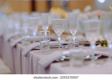 An elegantly set table featuring crystal glassware and a tasteful floral arrangement, perfect for special occasions.